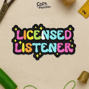May include: Embroidered patch with the words "LICENSED LISTENER" in colorful, bubble-style letters on a black background. The patch has a decorative border and star accents. The brand name "Cozy Patches" is in the top left corner.
