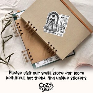 May include: A black and white sticker featuring a woman in a dress standing in front of a vanity mirror. The sticker has the text "COOL GIRLS KNOW HISTORY" printed below the image.