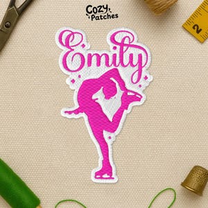 May include: Embroidered patch with a pink figure skater and the name "Emily". The patch is white with a pink skater design and text. The "Cozy Patches" logo is in the upper left corner. The patch is suitable for clothing or accessories.