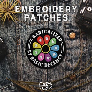 May include: Embroidered patch with the text "RADICALIZED BY BASIC DECENCY" in a circular design. The patch features a colorful flower with heart-shaped petals. The patch is on a denim jacket.