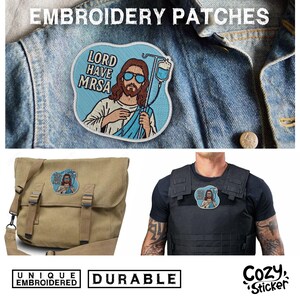 Puede incluir: Parches bordados con un Jes&uacute;s de dibujos animados con gafas de sol y el texto "LORD HAVE MRSA". Los parches se muestran en una chaqueta vaquera, un bolso mensajero y un chaleco t&aacute;ctico. Los parches se describen como &uacute;nicos y duraderos.