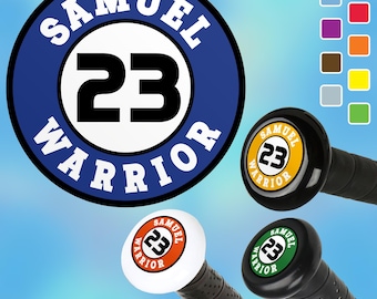 May include: A blue and white round sticker with the text "SAMUEL 23 WARRIOR" in white lettering. The sticker is shown on a black baseball bat handle.
