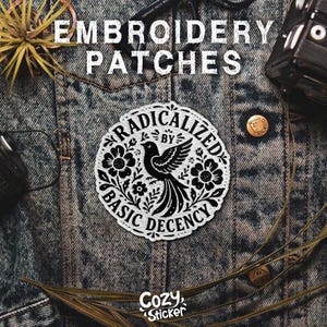 Puede incluir: Parche bordado blanco con un dise&ntilde;o de p&aacute;jaro negro, rodeado de elementos florales y la frase "RADICALIZED BY BASIC DECENCY". El parche est&aacute; sobre una chaqueta vaquera. El texto "EMBROIDERY PATCHES" est&aacute; en la parte superior. La marca "Cozy Sticker" est&aacute; en la parte inferior.