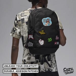 Puede incluir: Mochila negra adornada con parches coloridos, incluyendo una caricatura con el texto "LORD HAVE MRSA". La mochila tambi&eacute;n presenta parches con texto y gr&aacute;ficos. La imagen incluye el texto "UNLEASH YOUR CREATIVITY" y "DURABLE, ADHESION PATCHES".