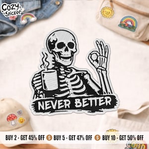 May include: Embroidered patch showing a black and white skeleton with a mug and an 'okay' hand gesture. The text "NEVER BETTER" is below the skeleton. The patch has a white border and is on a white surface.