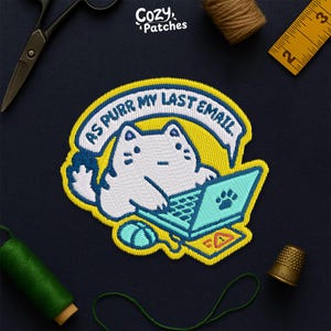 May include: Embroidered patch featuring a white cat working on a teal laptop with a paw print on the screen. The patch has the text "AS PURR MY LAST EMAIL" in a speech bubble. The patch is surrounded by yellow and blue stitching.