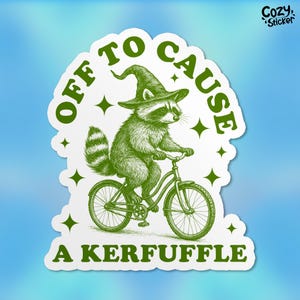 May include: A green sticker featuring a raccoon wearing a witch hat and riding a bicycle. The text "OFF TO CAUSE A KERFUFFLE" is in green around the raccoon. The sticker has a white border and a blue background.