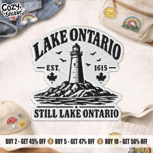 May include: A black and white embroidered patch featuring a lighthouse on a rocky shore with the text LAKE ONTARIO, EST. 1615, and STILL LAKE ONTARIO. The design includes small birds and maple leaf icons, rendered in detailed black thread on a white background.