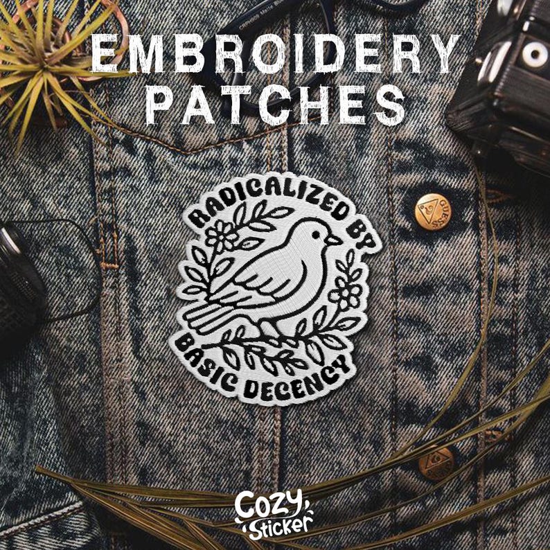 May include: White embroidered patch featuring a bird design, encircled by leaves and flowers, with the text "RADICALIZED BY BASIC DECENCY." The patch is displayed on a denim jacket. The words "EMBROIDERY PATCHES" are at the top.