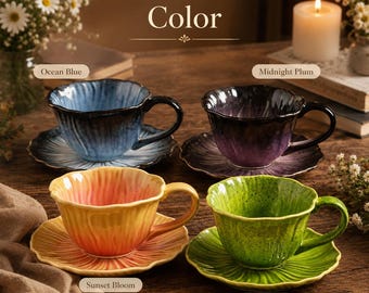 May include: Four ceramic teacups and saucers with a fluted, petal-like design. The colours are labelled as Ocean Blue, Midnight Plum, Sunset Bloom, and Moss Green. Each cup features a gradient glaze finish and a matching saucer with radial ridges.