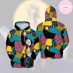 May include: A hooded sweatshirt featuring a colorful patchwork design in teal, yellow, black, and pink. The front displays a character illustration with long red hair and a stitched appearance. The back of the hoodie showcases the same patchwork pattern.