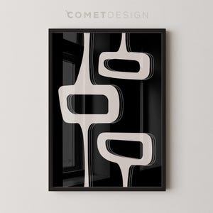 May include: Framed art print with a mid-century modern design. The artwork displays three abstract shapes in off-white against a black backdrop. The shapes have rounded edges and are outlined with a thin white border. The text "COMETDESIGN" is at the top.