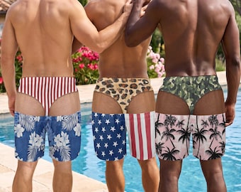 May include: Three pairs of swim trunks featuring trompe l'oeil designs. The first has red and white stripes above blue floral fabric. The second has a leopard print above an American flag pattern. The third has camouflage above a palm tree print.