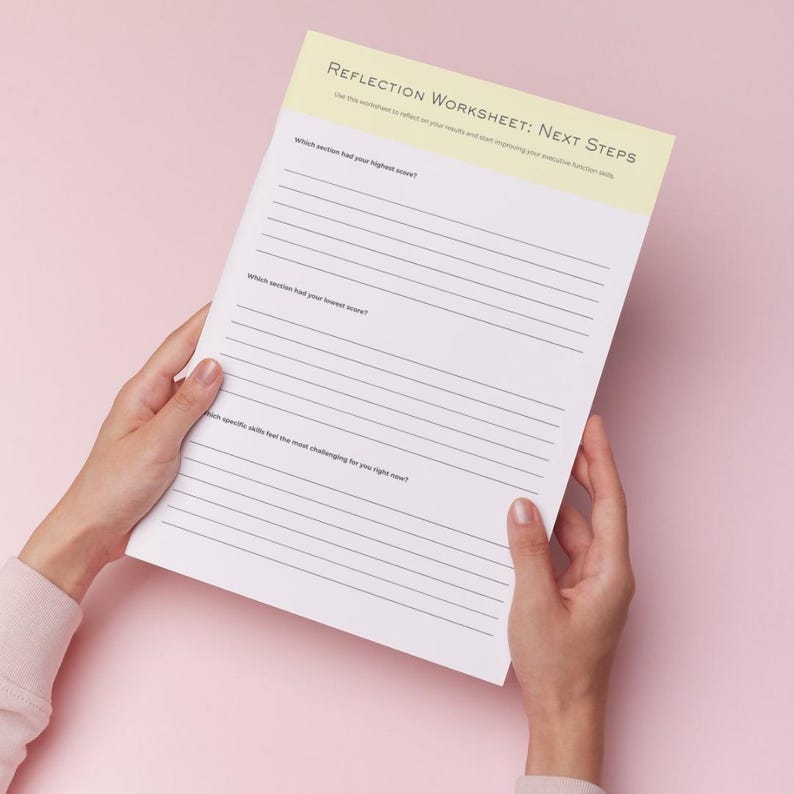 以下が含まれることがあります： ピンク色の背景に、手が持っている「Reflection Worksheet: Next Steps」というタイトルの白いワークシート。ワークシートの上部には、テキストが書かれた黄色のボーダーがあります。
