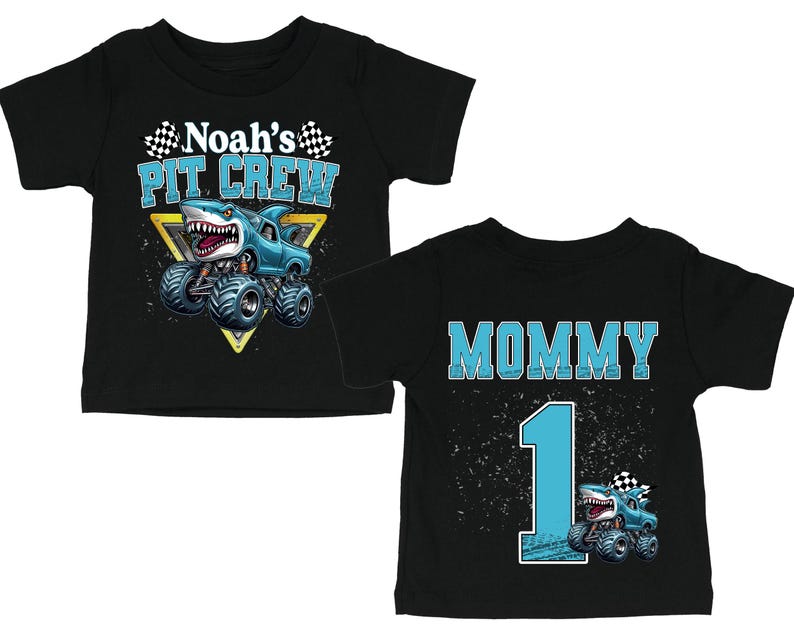 以下が含まれることがあります： モンスター・トラックのデザインが施された黒いベビーTシャツ。1枚は「Noah's PIT CREW」とサメをテーマにしたトラックが描かれています。もう1枚は「MOMMY」と「1」とモンスター・トラックが描かれています。どちらのシャツにもチェッカーフラッグが付いています。