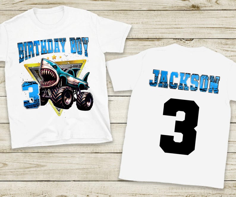 May include: White t-shirt featuring a shark monster truck design with the text "BIRTHDAY BOY" and the number "3". The back of the shirt displays the name "JACKSON" and the number "3".
