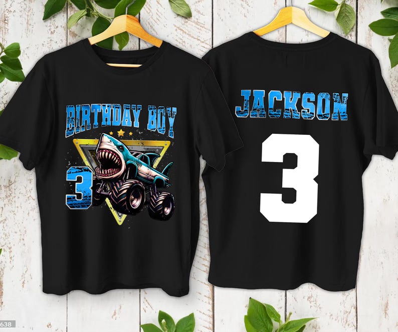 May include: Black t-shirts with a shark-themed design. The front features the text "BIRTHDAY BOY" and a shark monster truck with the number "3". The back displays the name "JACKSON" and the number "3".