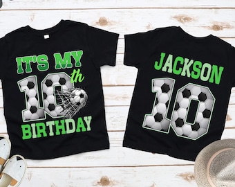 May include: Two black t-shirts with soccer-themed designs. One shirt says "It's My 10th Birthday" in green, with a soccer ball graphic. The other shirt says "Jackson 10" in green, with a soccer ball graphic.