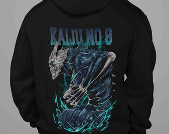 May include: Black hoodie featuring a detailed illustration of a skeletal creature with blue and teal accents. The text "KAIJU NO 8" is printed across the top in teal. The design is centered on the back of the hoodie.
