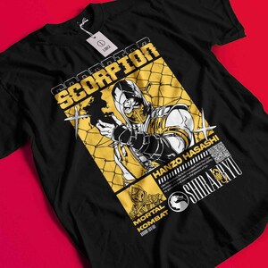 May include: Black t-shirt with a yellow and black graphic of the Scorpion character from Mortal Kombat. The design includes the text "SCORPION", "HANZO HASASHI", and "MORTAL KOMBAT". The shirt has a tag that says "LARGE".