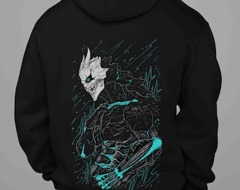 May include: Black hooded sweatshirt featuring a detailed illustration of a monster with a skull-like face and teal accents. The graphic design is on the back of the sweatshirt. The monster has a menacing appearance, with sharp teeth and a skeletal structure.