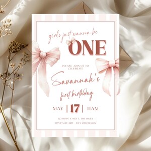 Puede incluir: Una tarjeta de invitación de cumpleaños rosa y blanca con el texto "girls just wanna be ONE" y "Savannah's first birthday". La tarjeta presenta lazos y rayas de acuarela, con la fecha 17 de mayo y la hora 11 AM.