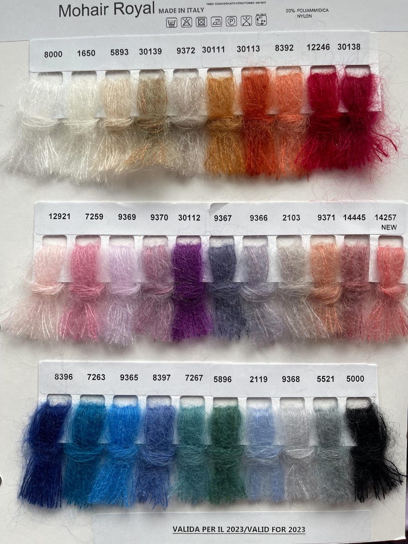 May include: A colour chart of mohair yarn samples with numbers and names. The yarn is a blend of mohair and nylon. The colours range from white to black, with shades of pink, purple, blue, green, and red.