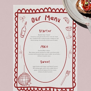May include: A menu card with a red border and text that reads "Our Menu". The menu lists a starter, main course, and sweet dessert. A plate with food and a patterned napkin are in the background.