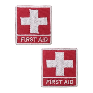 May include: Two red embroidered patches with a white cross and the text "FIRST AID" in white.