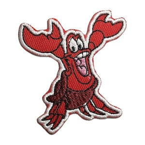 May include: Red embroidered iron-on patch of Sebastian the crab from Disney's The Little Mermaid. Sebastian is smiling with his mouth open and his eyes wide.