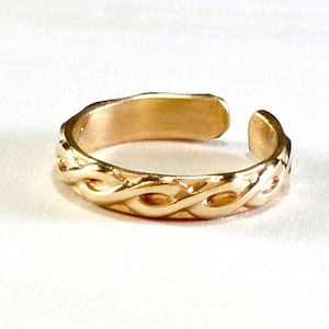 May include: A gold-toned adjustable ring with a braided design.