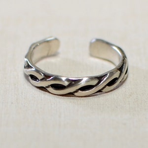May include: A silver toe ring with a braided design.