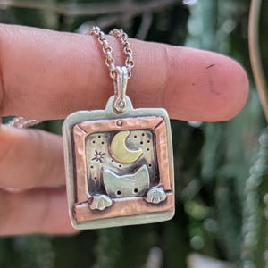 Collar con dije de metal mixto de gato asomándose por la ventana