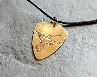 brass shield shaped pendant with hummingbird and adjustable leather cord