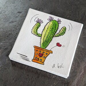 Puede incluir: Un lienzo pintado a mano con un cactus de dibujos animados con flores rosas y un coraz&oacute;n. El cactus est&aacute; en una maceta amarilla con corazones rojos. El lienzo est&aacute; firmado "W. Gasci".