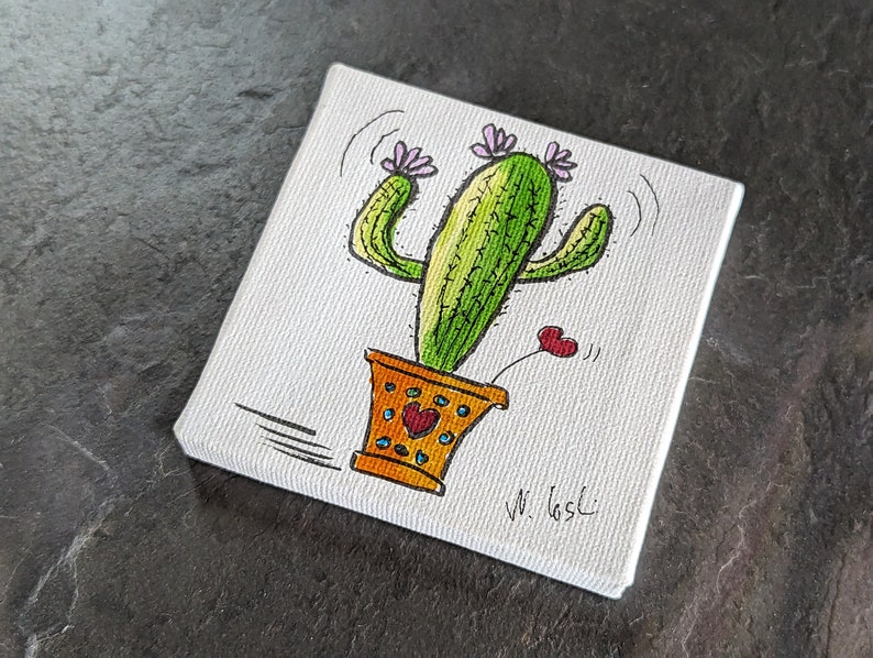 Puede incluir: Un lienzo pintado a mano con un cactus de dibujos animados con flores rosas y un coraz&oacute;n. El cactus est&aacute; en una maceta amarilla con corazones rojos. El lienzo est&aacute; firmado "W. Gasci".