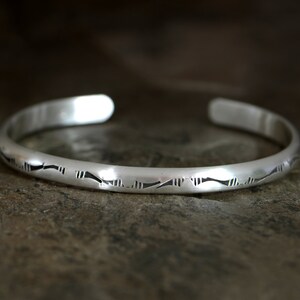sterling silver stacking cuff bracelet with a simple hand stamped pattern