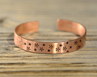 Copper cuff bracelet with small flowers and a hammered texture