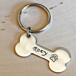 Silver bone shaped dog tag with name and phone number made from solid sterling silver