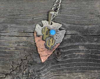 silver arrowhead with copper mountain and brass saguaro and a 5mm Kingman AZ turquoise