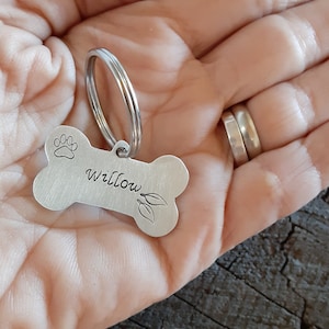 Silver dog tag in shape of bone