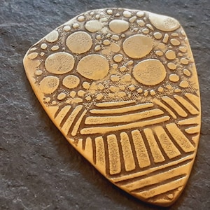 Brass shield guitar pick - playable with wild pattern - backside hammered - NicisPicks Original