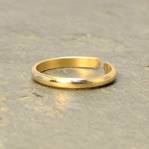 Peut inclure: Une bague d'orteil en or simple avec une surface lisse et arrondie.