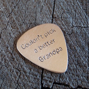 May include: Silver guitar pick with the text "Couldn't pick a better Grandpa" engraved on it.