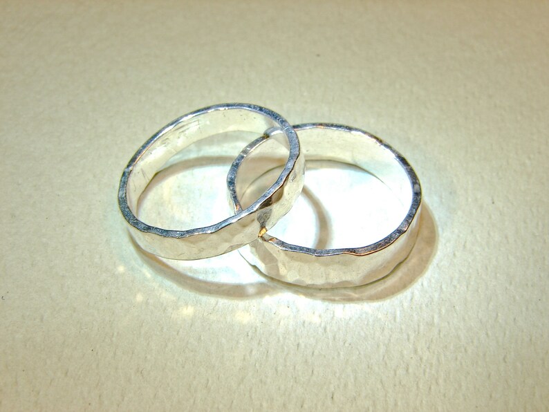 Puede incluir: Dos anillos de plata con textura martillada, entrelazados.