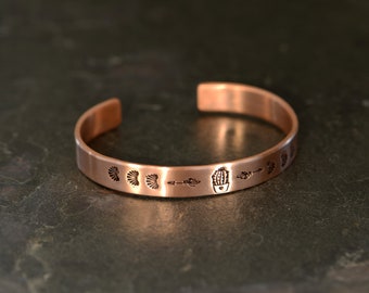 copper guitar pick bracelet with cactus in a pot , arrows and southwestern stamps