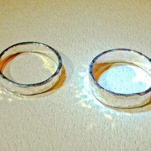 Puede incluir: Dos anillos de plata con textura martillada. Los anillos est&aacute;n sobre una superficie de color marr&oacute;n claro.
