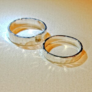 Puede incluir: Dos anillos de plata con textura martillada. Los anillos est&aacute;n apilados uno encima del otro.