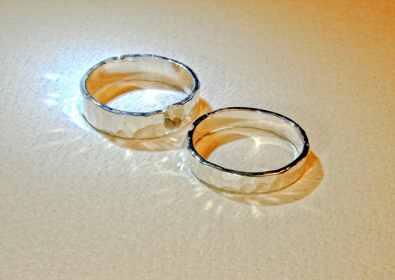 Puede incluir: Dos anillos de plata con textura martillada. Los anillos est&aacute;n apilados uno encima del otro.