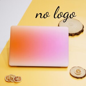 Puede incluir: Un ordenador port&aacute;til rosa y naranja con un dise&ntilde;o de color degradado. El port&aacute;til est&aacute; sobre una superficie amarilla.
